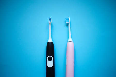 two ultrasonic electric toothbrushes on a blue background.の写真素材
