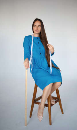 portrait of a young beautiful seamstress in blue dressの写真素材