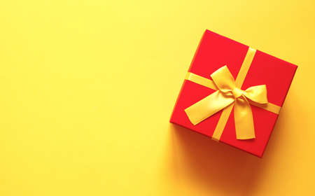 bright red gift box on yellow backgroundの写真素材