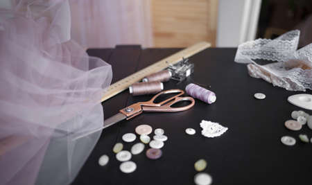 sewing supplies and fabrics lie on the tailor's table.の写真素材