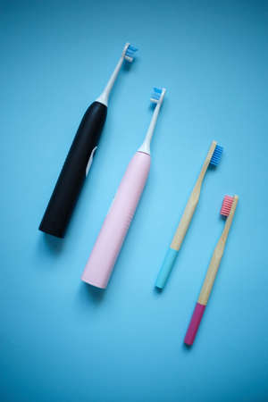 ultrasonic electric and bamboo toothbrushes on a blue background.の写真素材