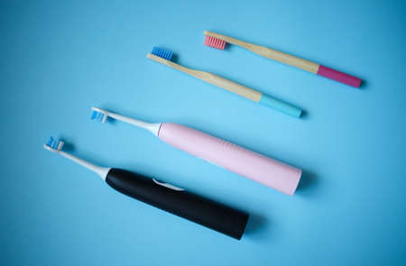 ultrasonic electric and bamboo toothbrushes on a blue background.の写真素材