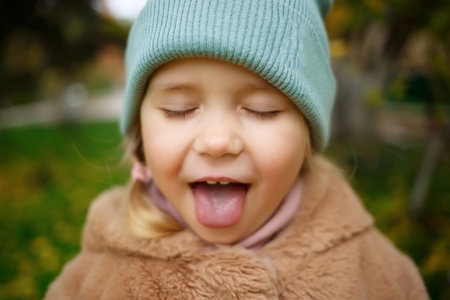 portrait of a little cute girl with sticking out tongue.の写真素材
