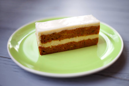 slice of carrot ginger pie on a green plate on a wooden backgroundの写真素材