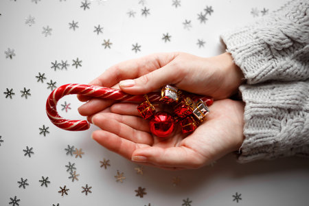 small Christmas decorations and lollipop in hands.の写真素材