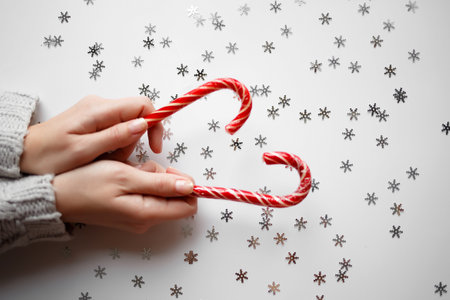 hands hold christmas lollipops on white backgroundの写真素材