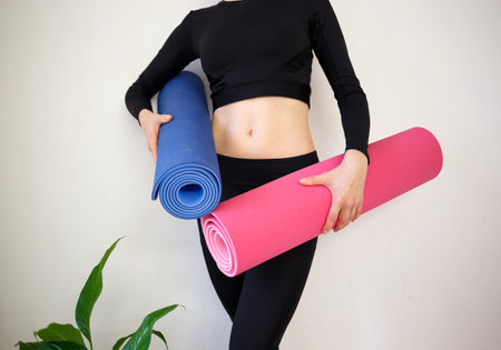 girl holding a pink and blue sports mat.の写真素材
