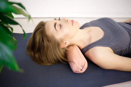 young woman doing exercises on a massage roller.の写真素材