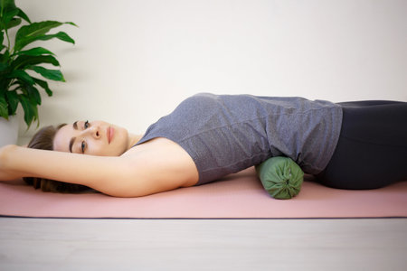 young woman doing exercises on a massage roller.の写真素材