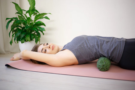 young woman doing exercises on a massage roller.の写真素材