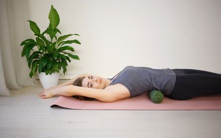 young woman doing exercises on a massage roller.の写真素材