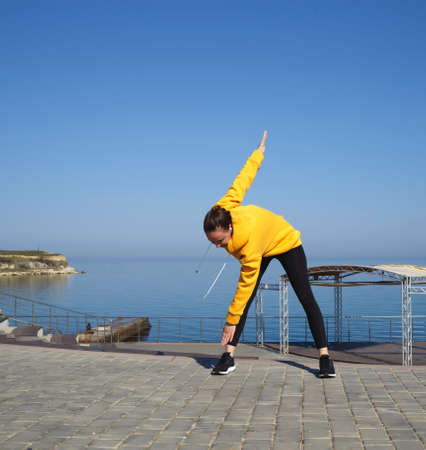 young woman doing sports outdoors by the sea.