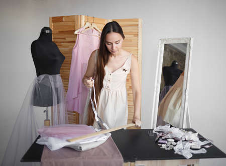 young beautiful seamstress trying on a new product.の写真素材