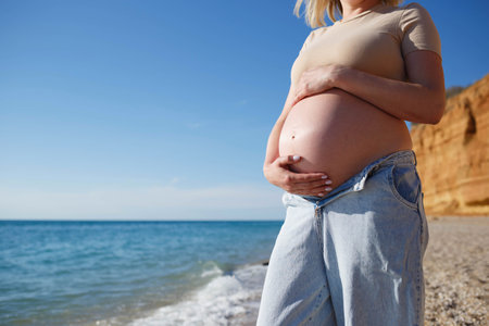 close-up photo. a pregnant woman sits on the seashore.の写真素材