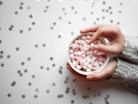 beautiful female hands hold a cup of cocoa with marshmallows. view from aboveの写真素材