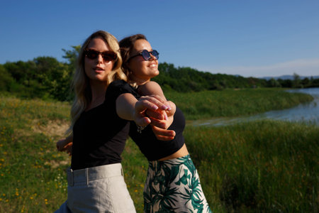 young beautiful women laughing standing by the lake