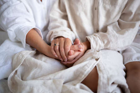 close-up shot: a young woman holds her mother's arms in her arms.の写真素材