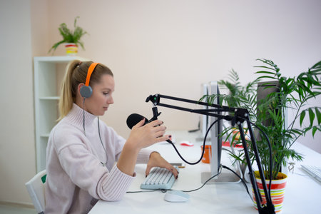 young woman is streaming while sitting in coworking at the computer.の写真素材