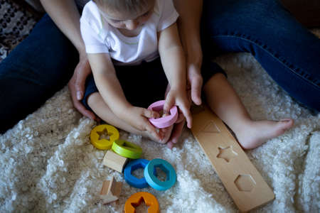 little boy plays with young beautiful mom in the bedroom.の写真素材