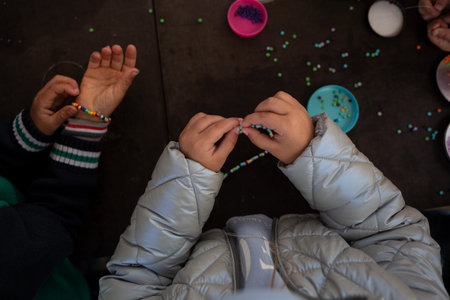 little children's hands weave a bead bracelet close-up shot.の写真素材