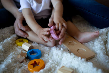 little boy plays with young beautiful mom in the bedroom.の写真素材