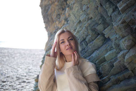portrait of a young beautiful woman on the seashore against the background of rocks.の写真素材
