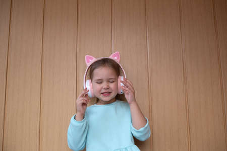 portrait of a little cute girl dancing with headphones on her headの写真素材