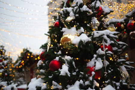 beautiful multi-colored toys on a Christmas tree against the background of lights and snow.の写真素材