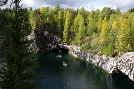 boats floating on the lake in the marble canyon surrounded by autumn forest.の写真素材