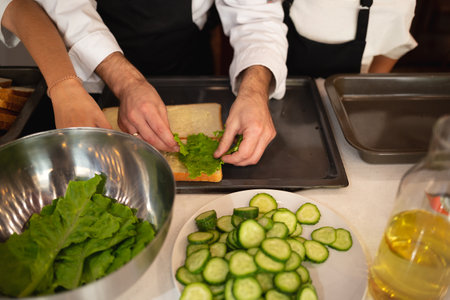 close-up shot. hands holding fresh chicken toast at food preparation master class.の写真素材
