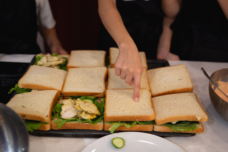 close-up shot. hands holding fresh chicken toast at food preparation master class.の写真素材