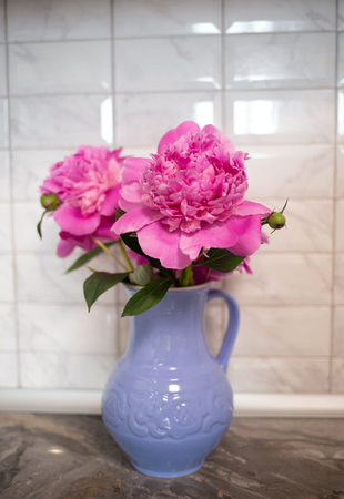 beautiful fresh pink peonies in a crock blue jug.の写真素材