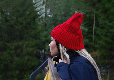 portrait of a young beautiful asian woman in a red hat looking into the distanceの写真素材
