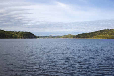 view of a mountain lake surrounded by bushes and trees in autumn.の写真素材