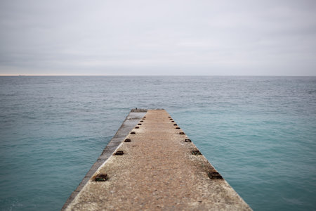 a pier that splits into two at the end and goes out to sea. great background for design.の写真素材