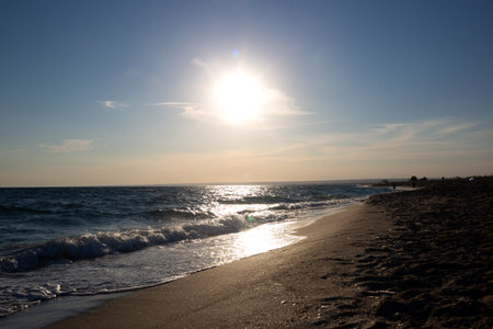 beautiful natural sandy beach with waves at sunset.の写真素材