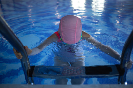 little cute girl performs exercises at the training in the poolの写真素材