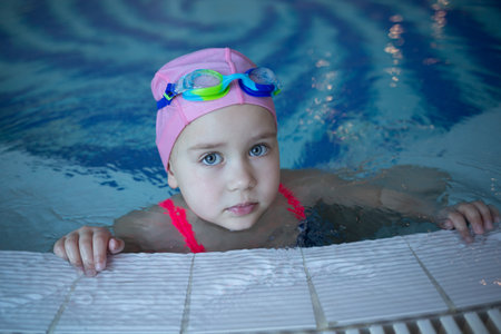 little cute girl performs exercises at the training in the poolの写真素材