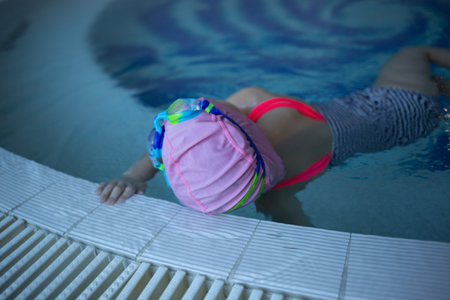 little cute girl performs exercises at the training in the pool.の写真素材
