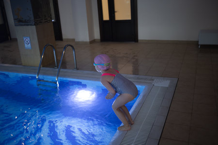 little cute girl performs exercises at the training in the pool.の写真素材