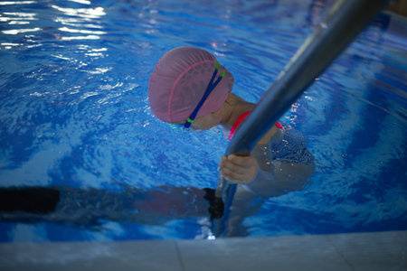 little cute girl performs exercises at the training in the pool.の写真素材