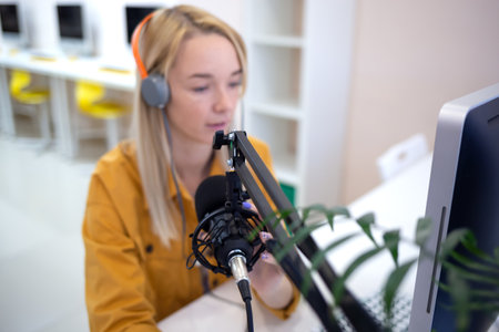 young woman is streaming while sitting in coworking at the computerの写真素材