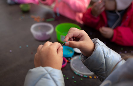 little children's hands weave a bead bracelet close-up shot.の写真素材