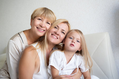 family portrait: mom, daughter and granddaughter are sitting on the bed