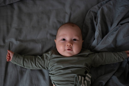 An adorable baby smiling happily while lying down, capturing a moment of pure innocence
