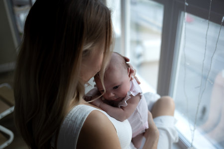 young beautiful woman kisses her little cute daughter. family portraitの写真素材