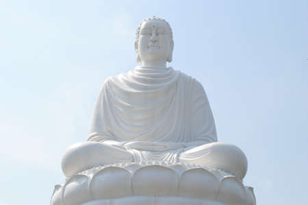 White statue of a seated Buddha on the background of light blue sky in Nha Trang, Vietnamの写真素材