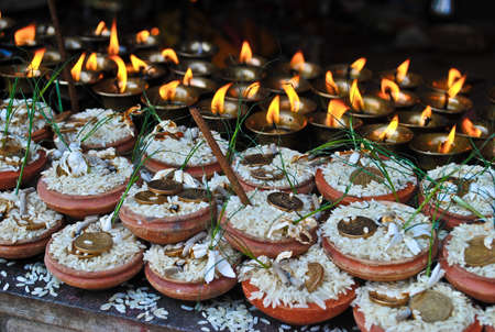 Nepalese religious ritual: a grain of rice coins candles. Swayambhunath stupa in Kathmandu Nepalの写真素材