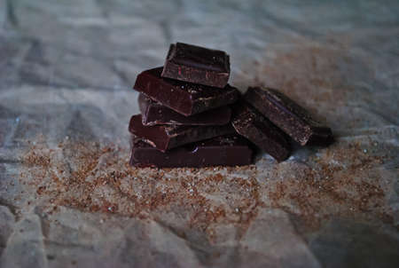 Pieces of chocolate and cinnamon chips on the dark  paperの写真素材