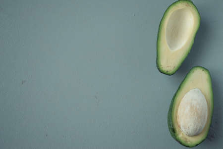 Halved avocado on light gray particleboard backgroundの写真素材